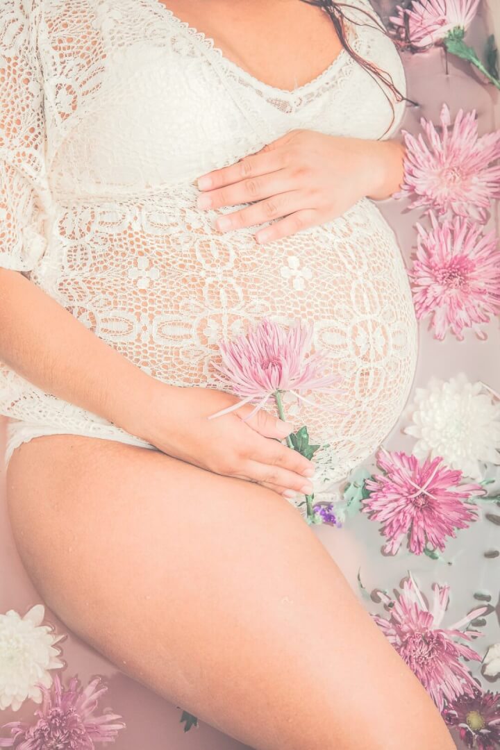 Body of pregnant woman holding her belly. Great example of artistic maternity photography.