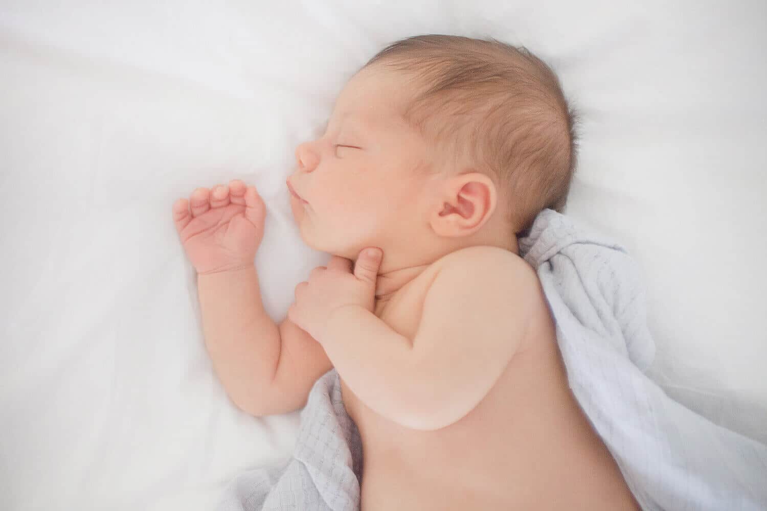 Newborn baby laying on bed