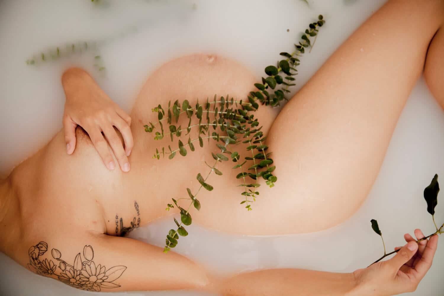 Pregnant woman showing her womb in a bathtub, artistic maternity photography