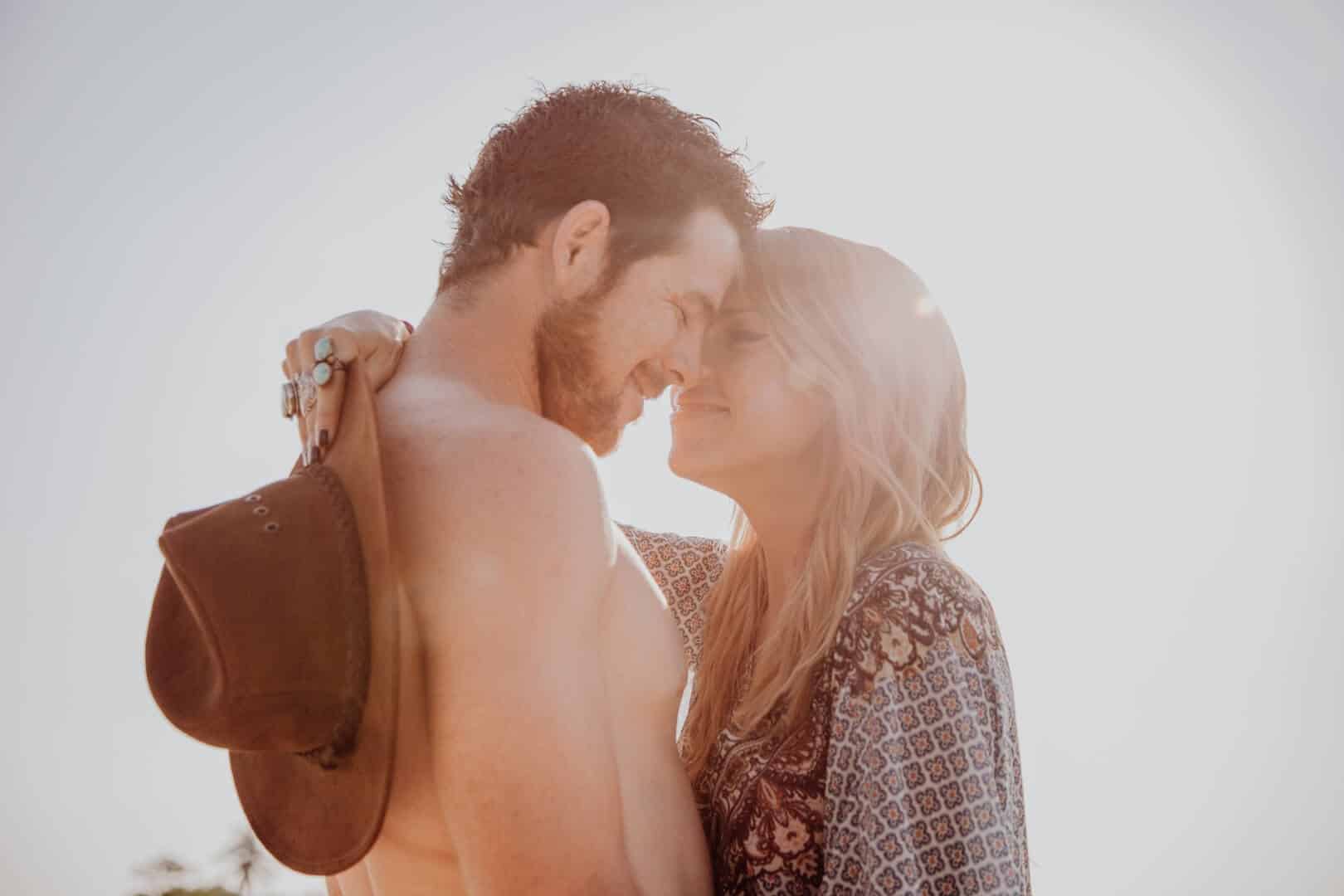 Couple kissing with sunlight right in the middle of them