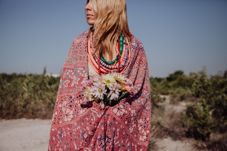 Woman wearing a poncho and holding flowers
